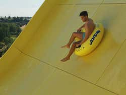 Um menino descendo pelo tobogã do parque aquático
