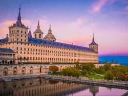 Real Monasterio de San Lorenzo de El Escorial com as cores do entardecer no céu ao fundo