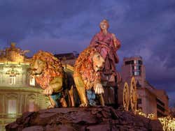 Fonte de Cibeles com edifícios iluminados no fundo