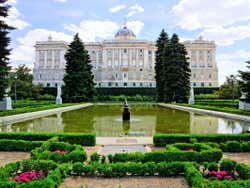 Jardins do Palácio Real de Madrid com o edifício do palácio no fundo