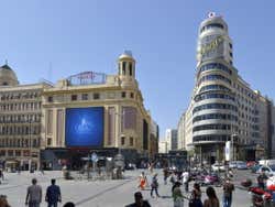 Praça de Callao de Madrid com o cartaz da schweppes no fundo
