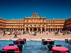 Plaza Mayor de Salamanca com mesas e pessoas caminhando pelo centro