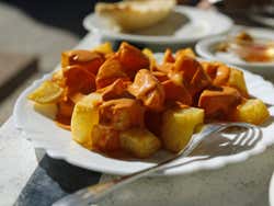 Um prato de patatas bravas com molho